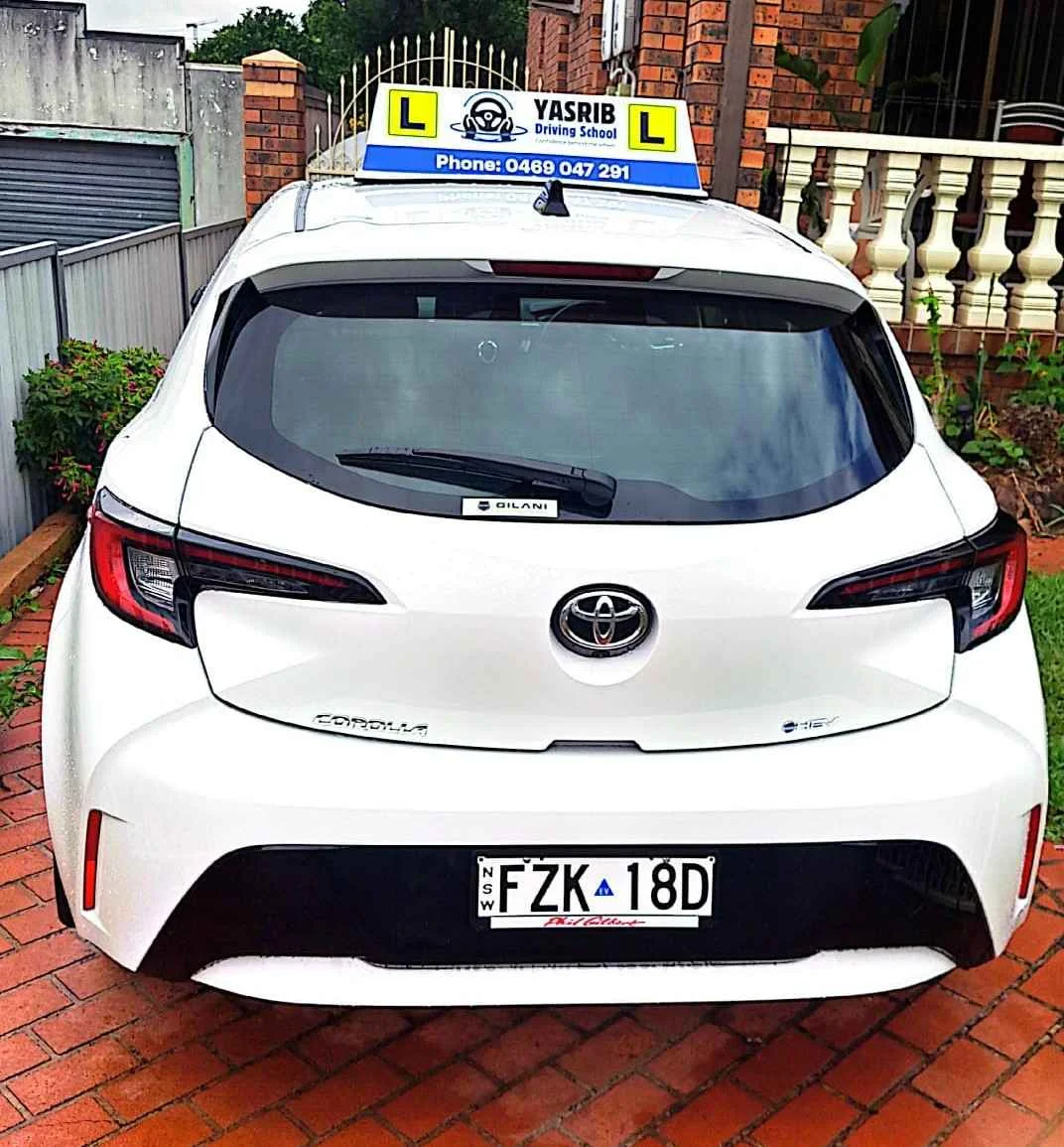 Yasrib Driving School test car with roof learner sign parked outdoors.